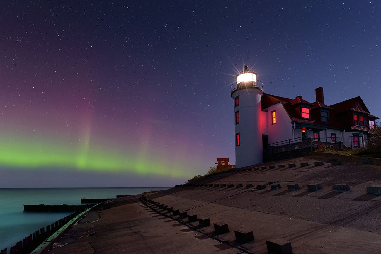 Northern Lights dancing in the night sky at Point Betsie Lighthouse, lake Michigan