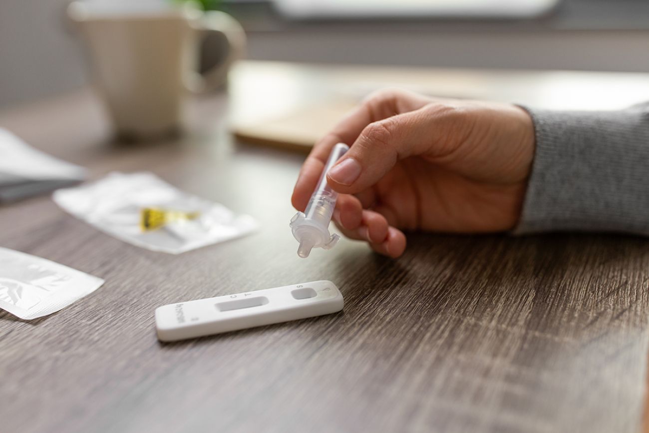 close up of woman making self testing coronavirus test at home
