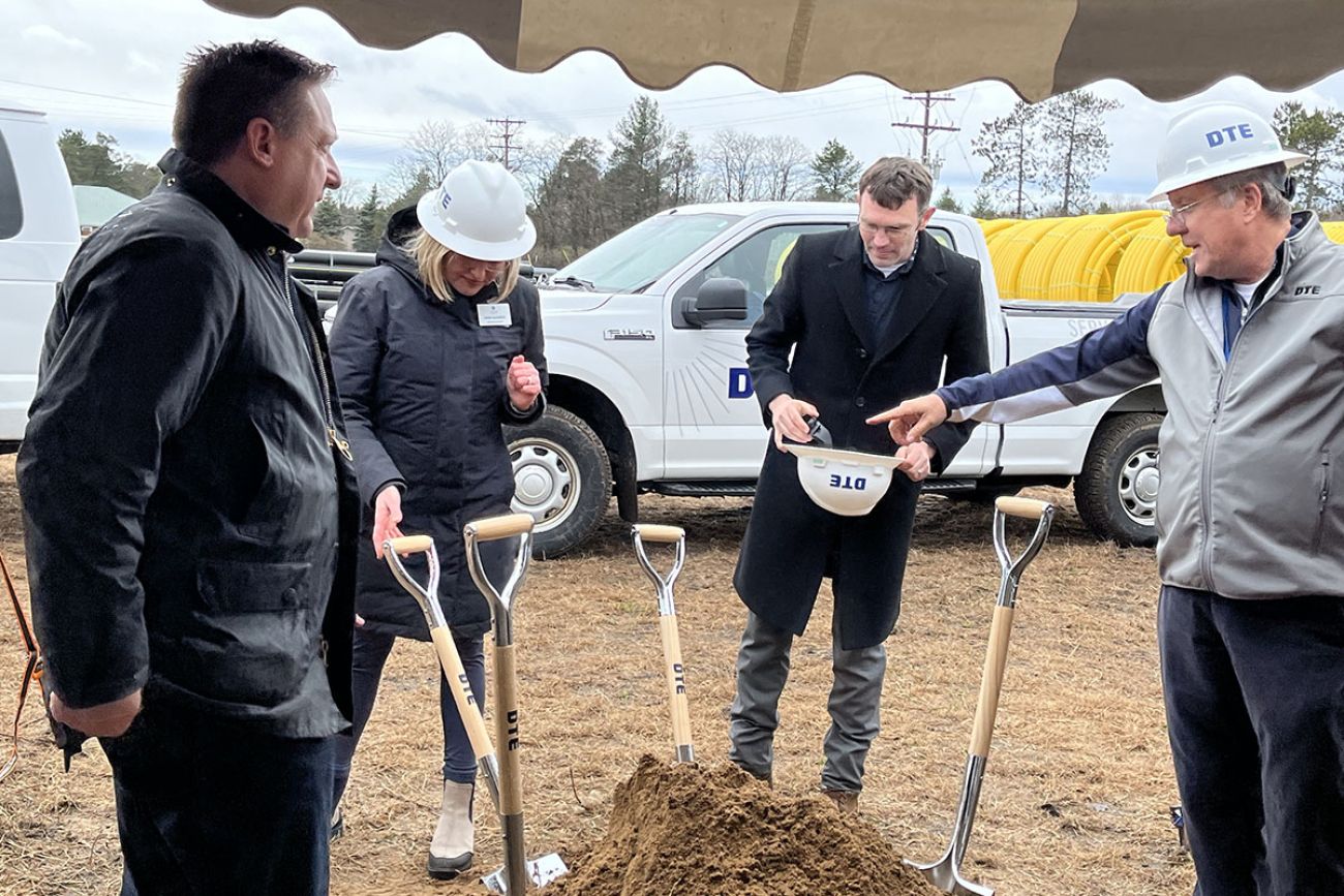 people standing in a circle with shovels