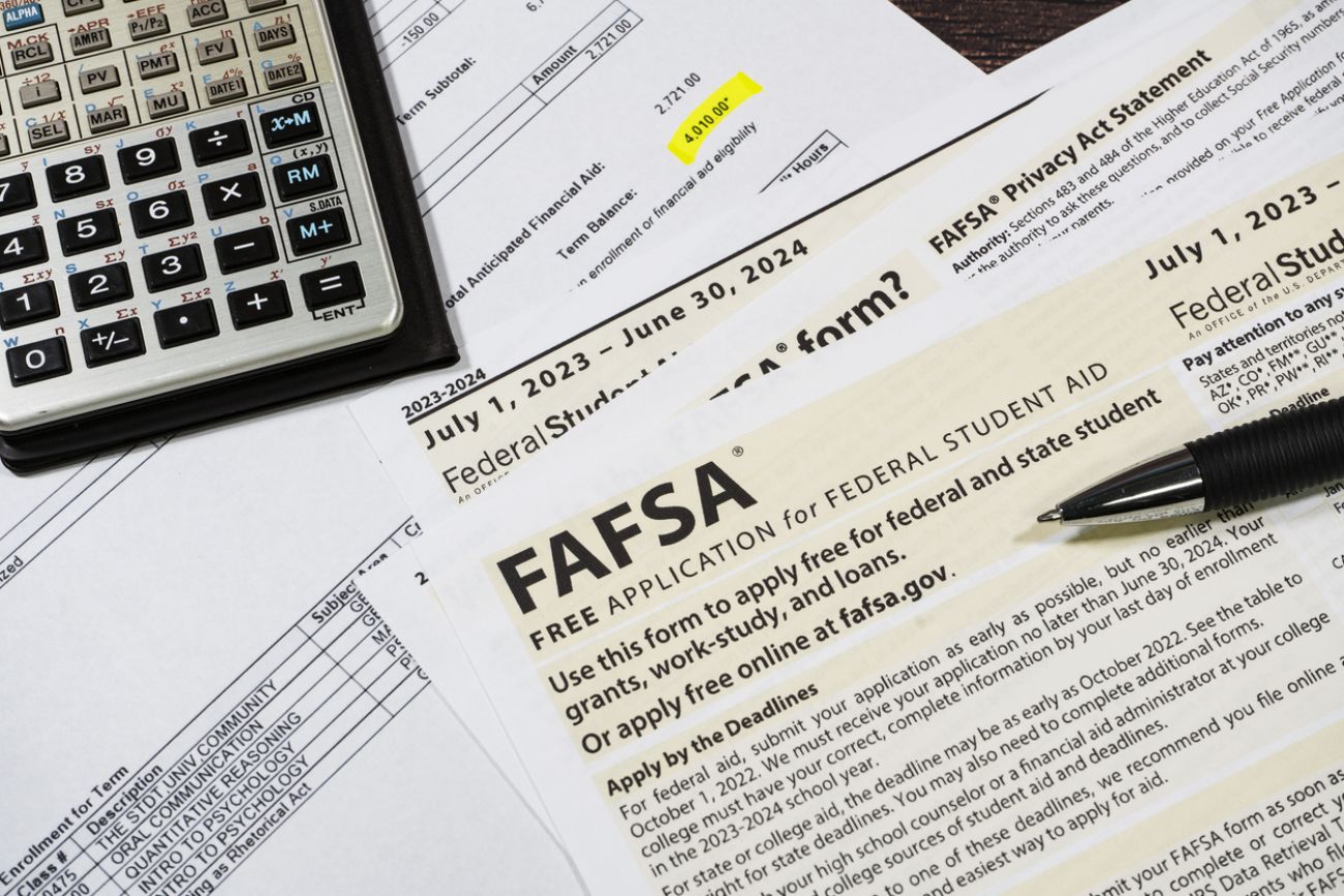 Close up of federal financial aid application with calculator and tuition statement