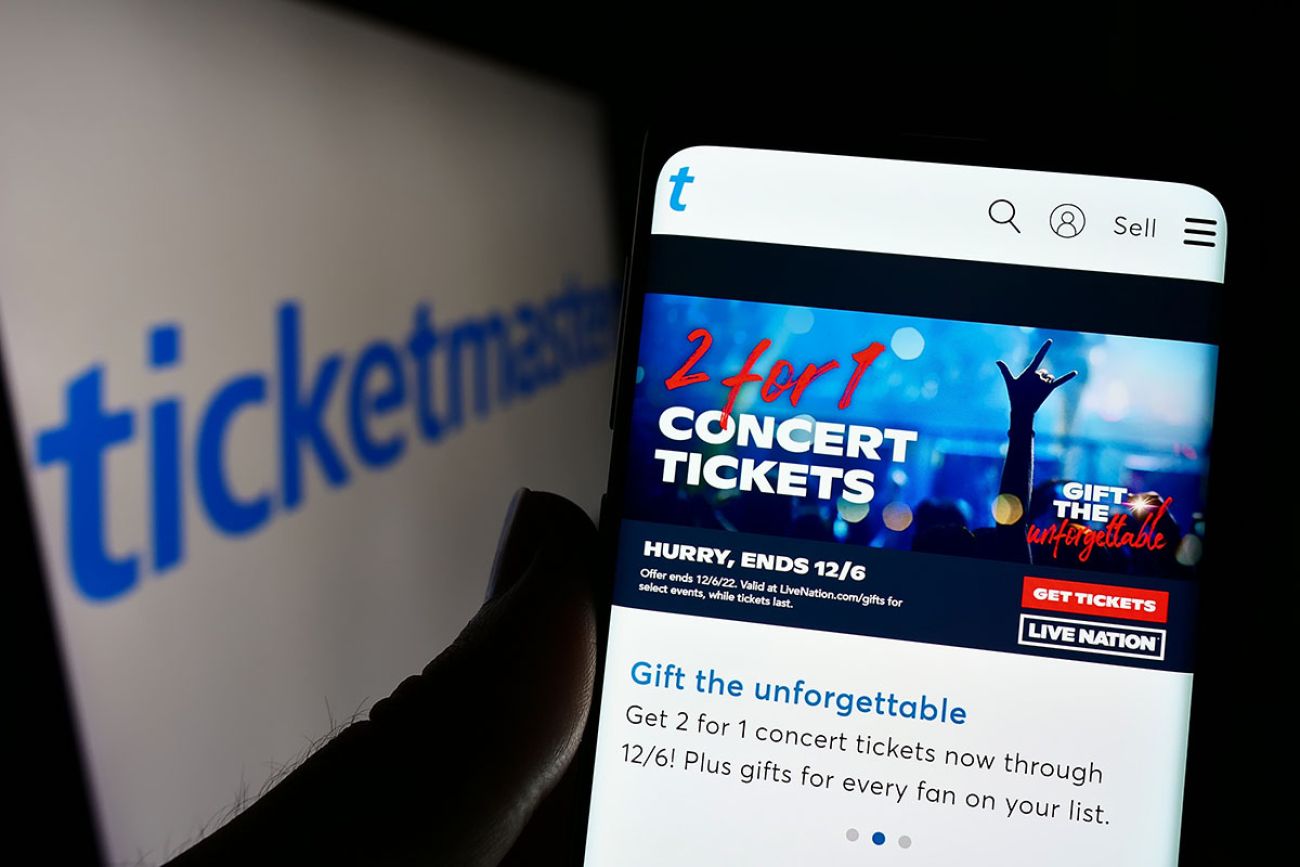 Person holding smartphone with webpage of US company Ticketmaster Entertainment Inc. on screen in front of logo.