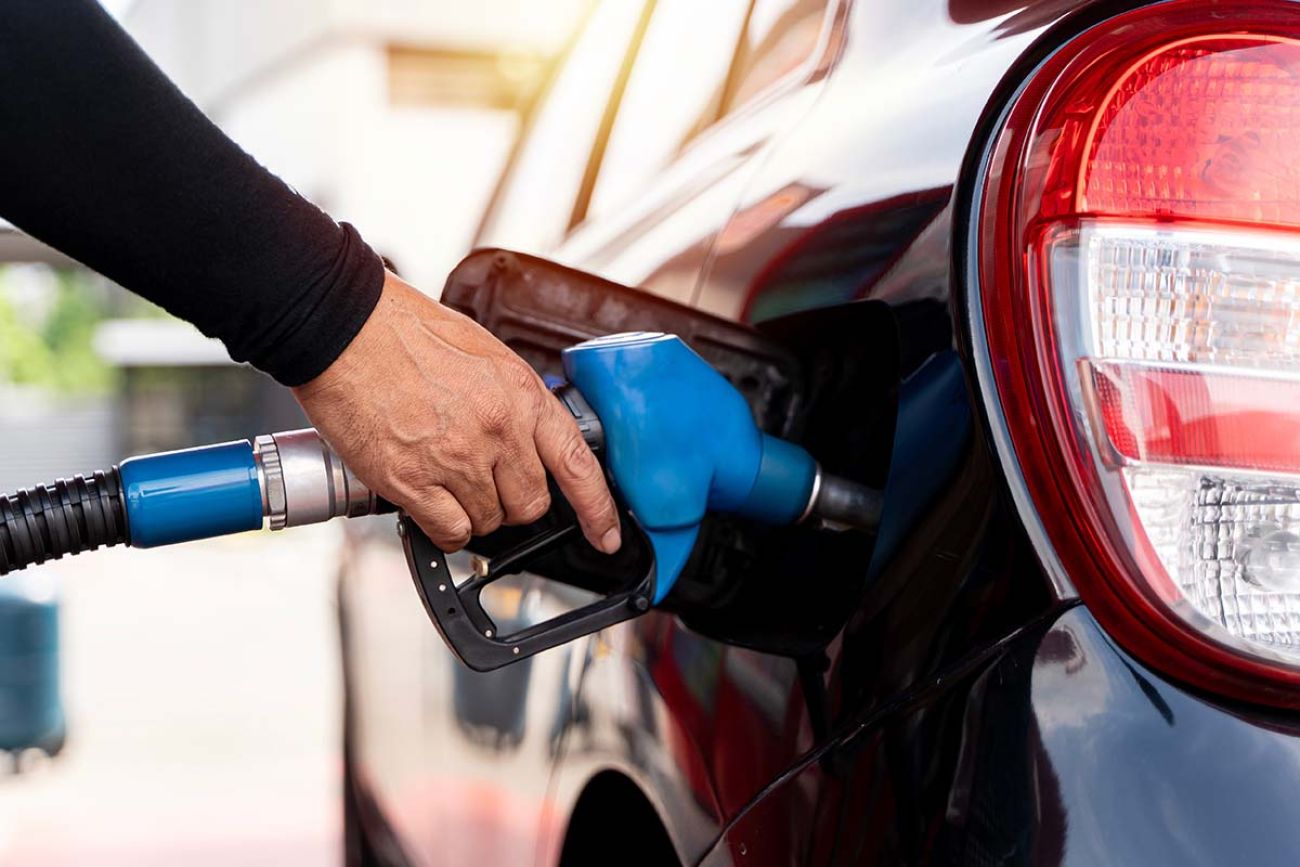 driver hand refilling and pumping gasoline oil the car with fuel at he refuel station.