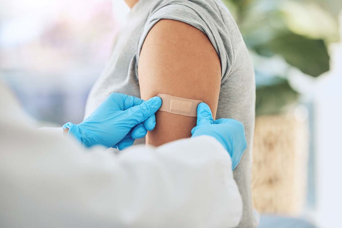 vaccine and doctor hands with plaster on patient arm in a medical hospital or clinic.