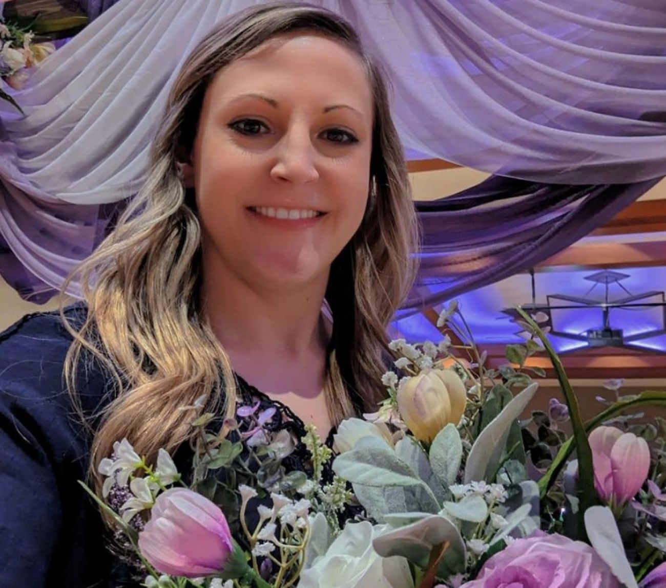 Lindsey Thurlow takes a selfie while holding flowers