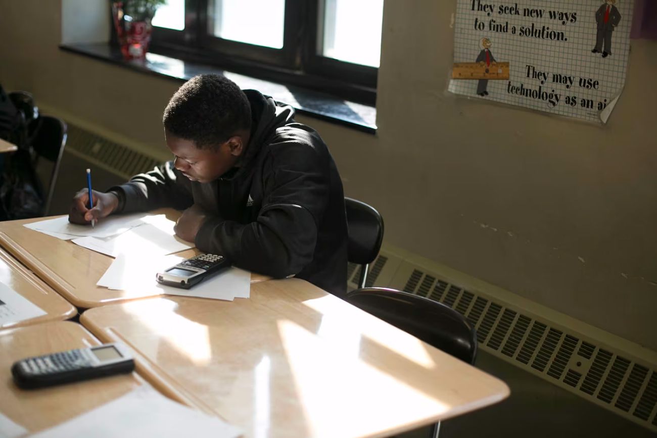 Student working at a desk in a classroom.