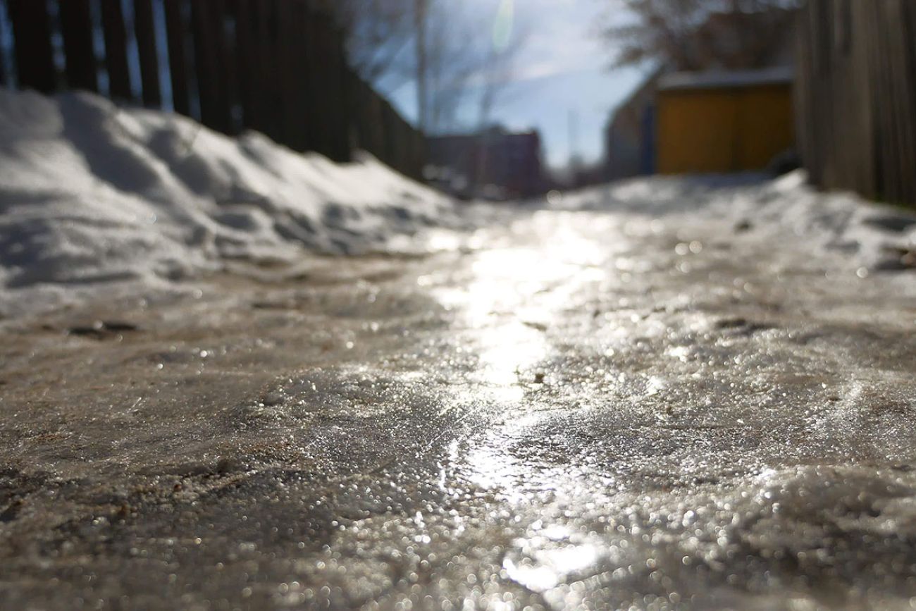A sidewalk covered in ice and snow.