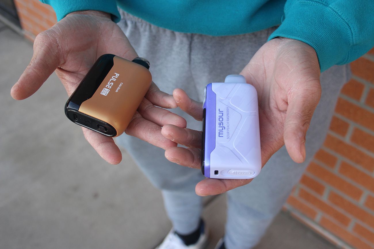 Someone holding two vaping products.