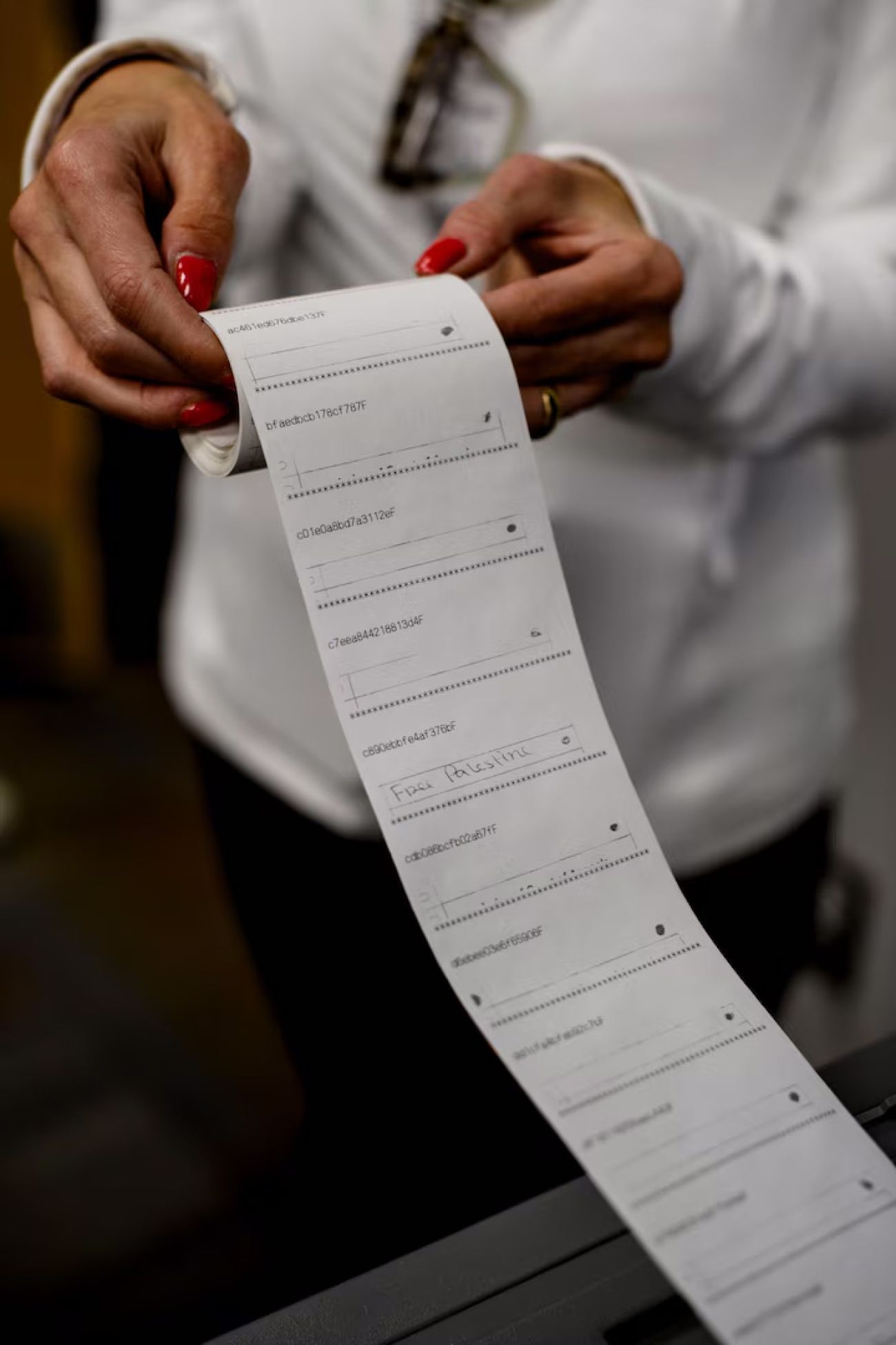 An election worker in Warren, Michigan looking at skinny paper.