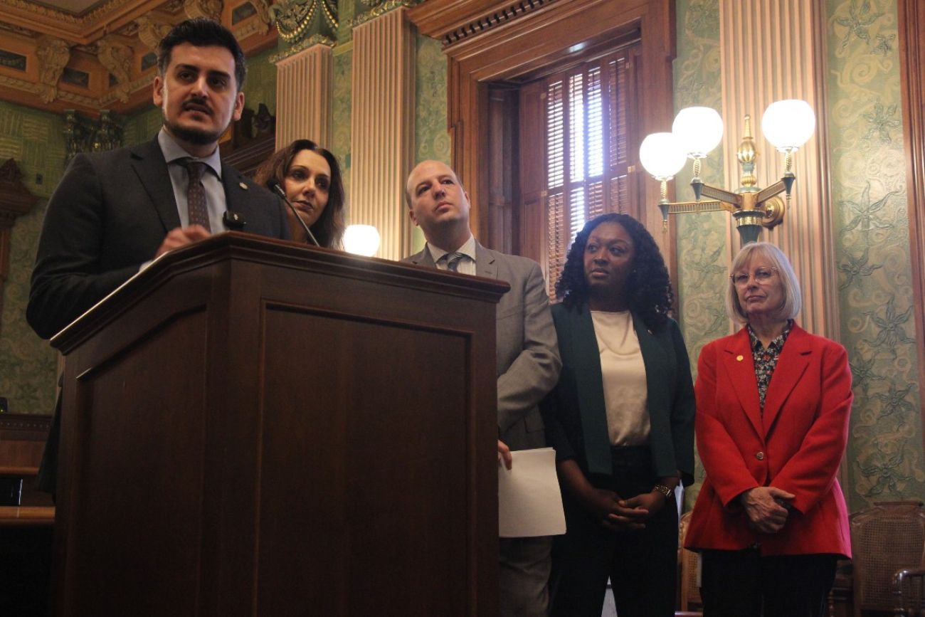 Lawmakers stand at a podium as they discuss a proposed funding plan for Michigan schools