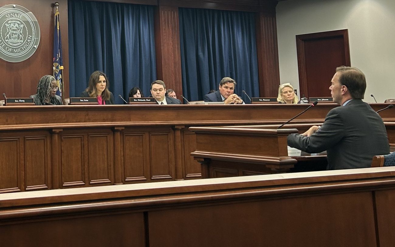 Sen. Dayna Polehanki sitting behind a table with other lawmakers.