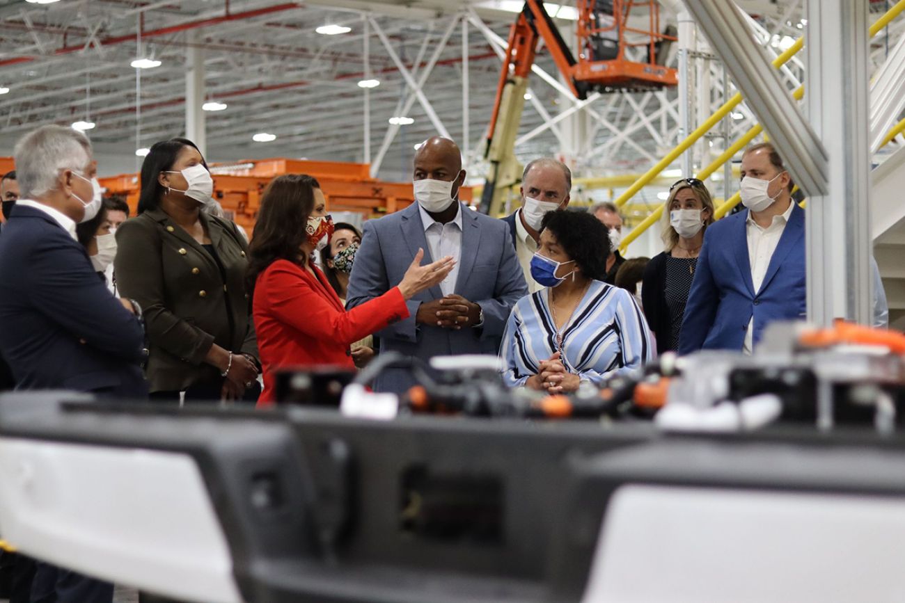 Gov. Gretchen Whitmer at the Ford Motor Co. plant in Dearborn, Michigan. People are wearing maps.