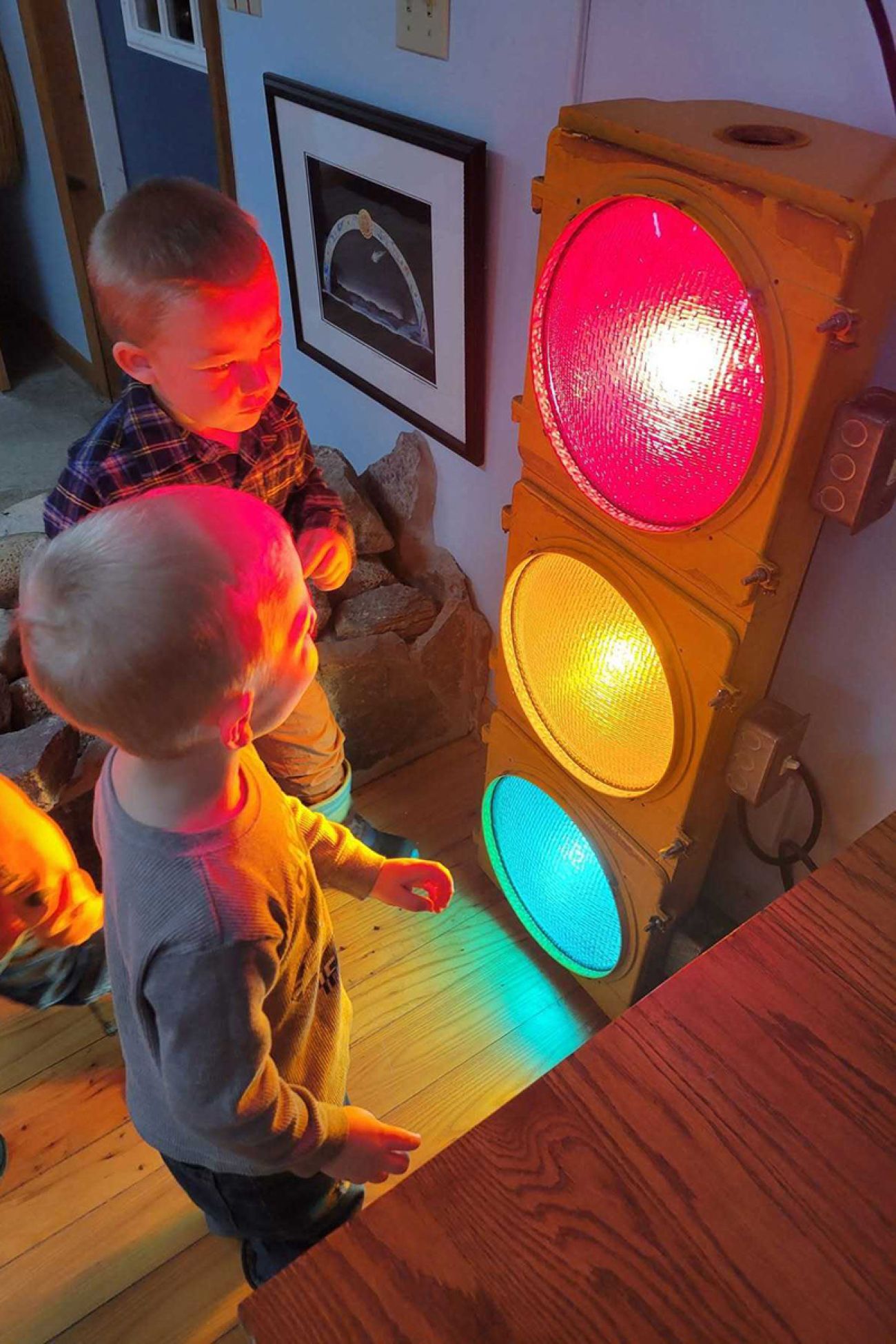 Two small children looking at a big traffic light.