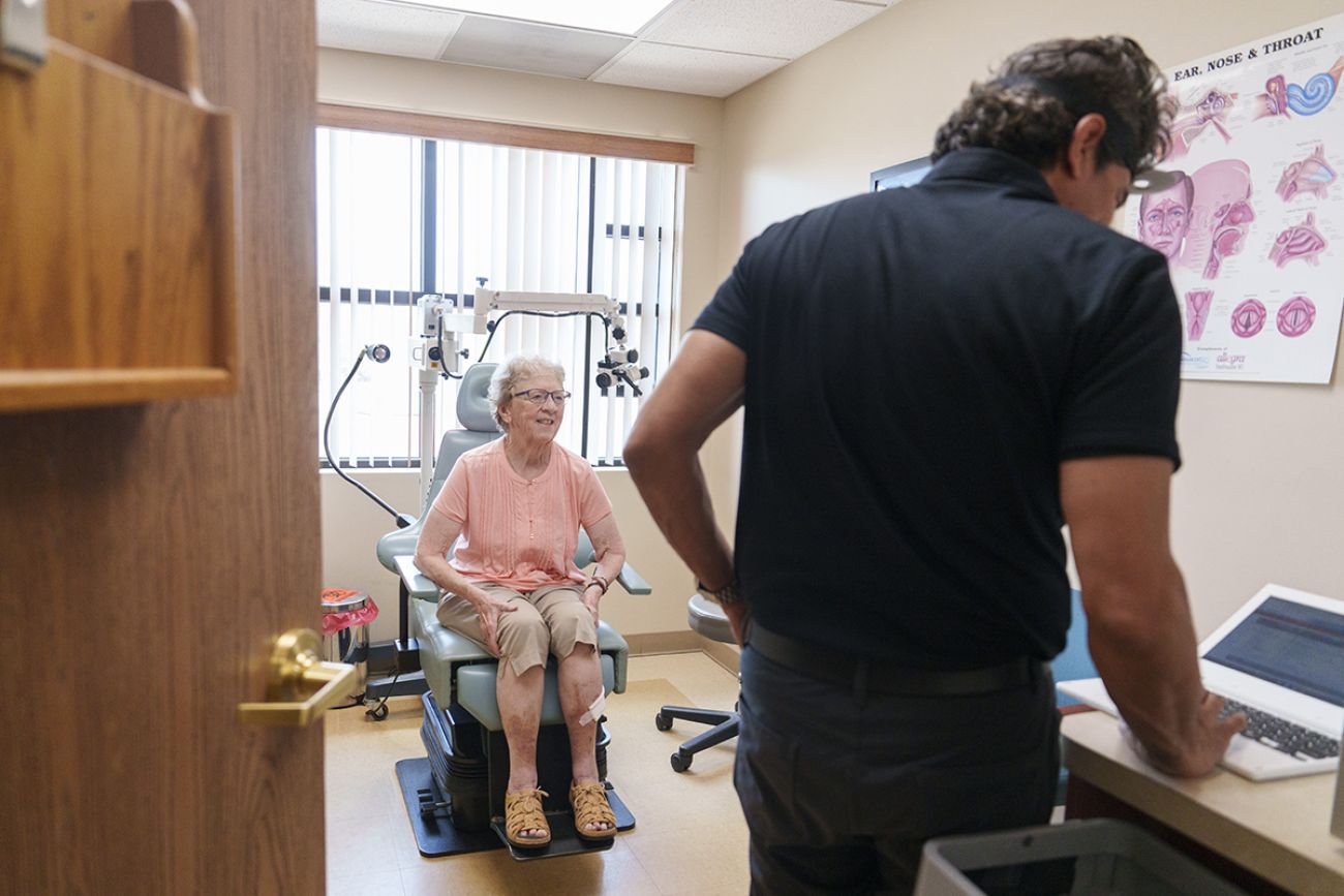 Dr. Bobby Mukkamala in a medical room with an older woman.