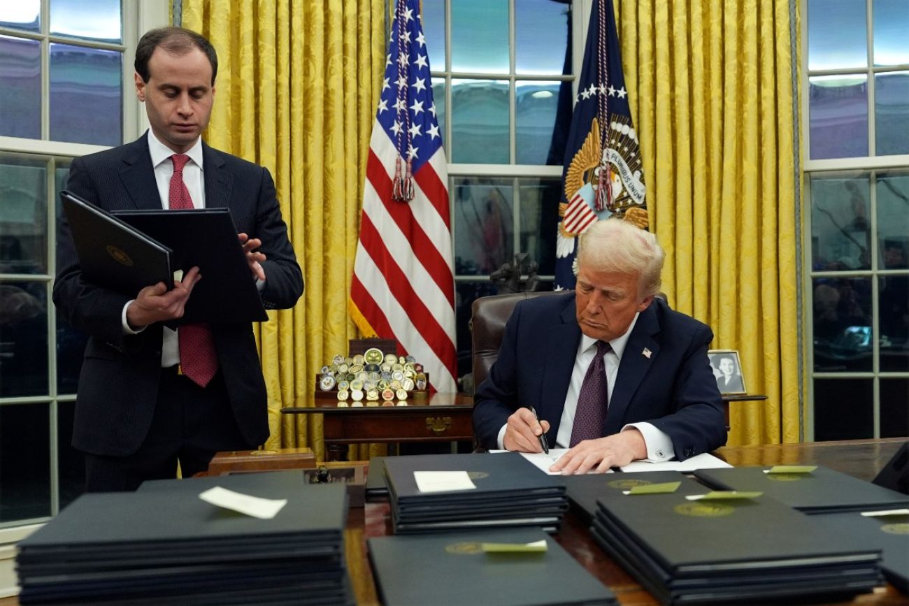 Trump signs an executive order in the Oval Office