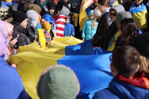 Many people holding an Ukrainian flag. 