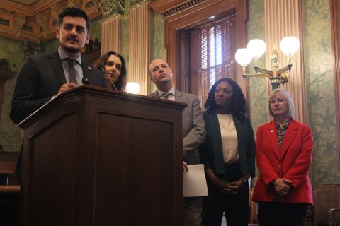 Lawmakers stand at a podium as they discuss a proposed funding plan for Michigan schools