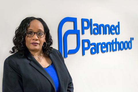 Paula Thornton Greear standing next to a wall with the words "Planned Parenthood."