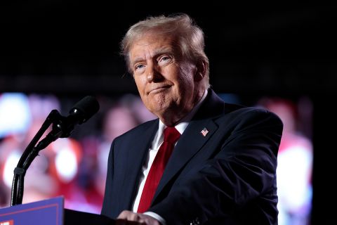 Donald Trump speaking a microphone. 