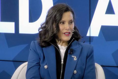 Gov. Gretchen Whitmer, blue background behind her.