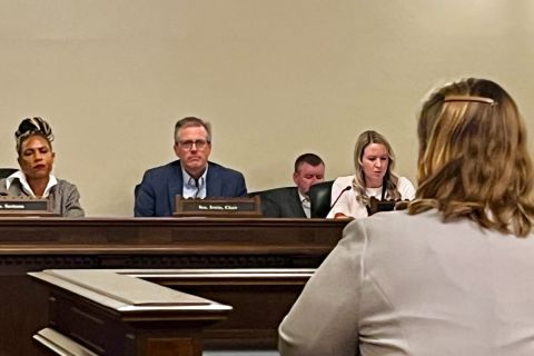 Woman sits in front of a panel