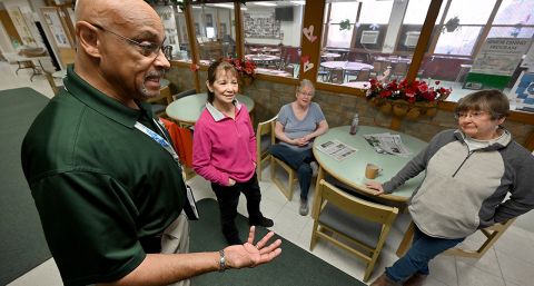 Cam McClure, wearing a green polo, talks to volunteers at the Waterford Senior Center.