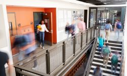 Busy high school corridor with blurred students and staff