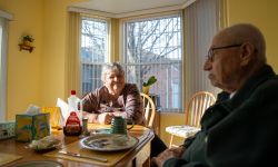 Two older people sitting at a kitchen table.