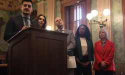 Lawmakers stand at a podium as they discuss a proposed funding plan for Michigan schools