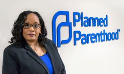 Paula Thornton Greear standing next to a wall with the words "Planned Parenthood."