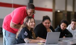 A college advisor helps students with schoolwork