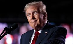 President Donald Trump speaks into microphone