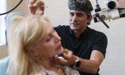 Dr. Bobby Mukkamala sees a woman patient in a medical office.